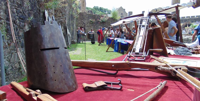 un heaume de chevalier est posé sur une table recouverte d'une nappe rouge.